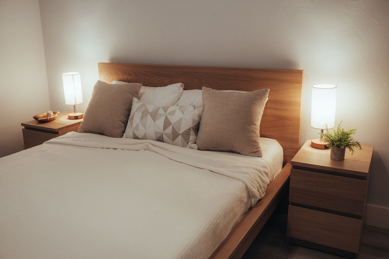 A warm, inviting bedroom with modern decor and soft lighting, perfect for relaxation.